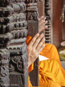 Hands of monks folded in prayer